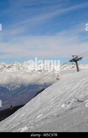 Panoramic view of wide and groomed ski piste in resort of Pila in Valle d'Aosta, Italy during winter. View Towards north is Switzerland and its iconic Stock Photo