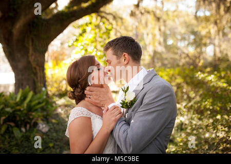 Newly married couple having intimate moment in garden Stock Photo