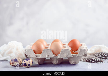 Brown eggs in craft carton pack on a light background. Fresh ingredients for Easter cooking. High key header with copy space. Stock Photo