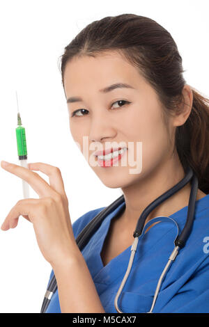 Evil Asian doctor or nurse holding a syringe filled with green medication isolated on a white background Stock Photo