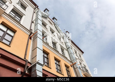 courtyard facade of urban apartment building against cloudy sky. view from bottom.