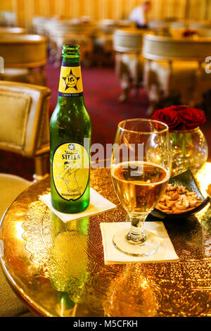 A bottle of Stella Egyptian Beer or lager and a glass in a hotel lounge bar Stock Photo