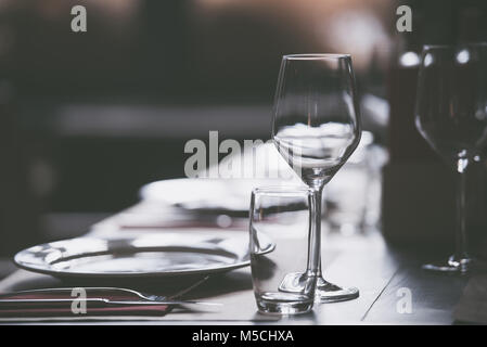 Plates and empty glasses served on a table in a restaurant ready for a celebration Stock Photo