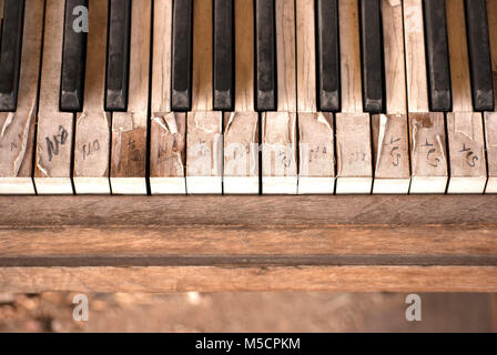 A vintage upright piano sits artistcally on a downtown street corner. Its keys share a cryptic message. Artistic textures and backgrounds. Stock Photo