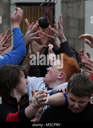 Boys tussle for the leather ball during the annual 'Fastern Eve Handba' event on Jedburgh's High Street in the Scottish Borders. The annual event, which started in the 1700's, involves two teams, the Uppies (residents from the higher part of Jedburgh) and the Doonies (residents from the lower part of Jedburgh) getting the ball to either the top or bottom of the town. The ball, which is made of leather, stuffed with straw and decorated with ribbons is thrown into the crowd to begin the game. Photo credit should read: Andrew Milligan/PA Wire. Stock Photo