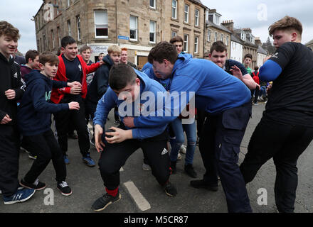 Boys tussle for the leather ball during the annual 'Fastern Eve Handba' event on Jedburgh's High Street in the Scottish Borders. The annual event, which started in the 1700's, involves two teams, the Uppies (residents from the higher part of Jedburgh) and the Doonies (residents from the lower part of Jedburgh) getting the ball to either the top or bottom of the town. The ball, which is made of leather, stuffed with straw and decorated with ribbons is thrown into the crowd to begin the game. Photo credit should read: Andrew Milligan/PA Wire. Stock Photo