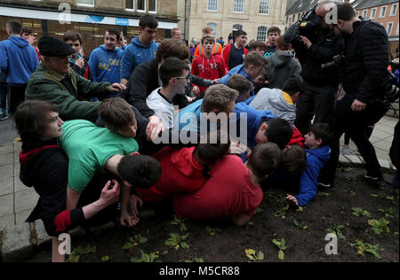Boys tussle for the leather ball during the annual 'Fastern Eve Handba' event on Jedburgh's High Street in the Scottish Borders. The annual event, which started in the 1700's, involves two teams, the Uppies (residents from the higher part of Jedburgh) and the Doonies (residents from the lower part of Jedburgh) getting the ball to either the top or bottom of the town. The ball, which is made of leather, stuffed with straw and decorated with ribbons is thrown into the crowd to begin the game. Photo credit should read: Andrew Milligan/PA Wire. Stock Photo