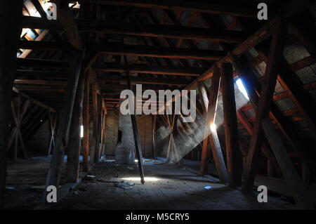 Wooden beams, attic, wooden roof of an old building with ray of sunlight. Stock Photo