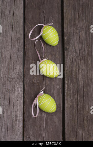 Easter painted pastel green eggs with ribbon on wooden background. Concept. Top view. Stock Photo