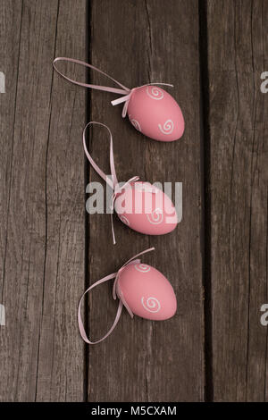 Easter painted pastel pink eggs with ribbon on wooden background. Concept. Top view. Stock Photo