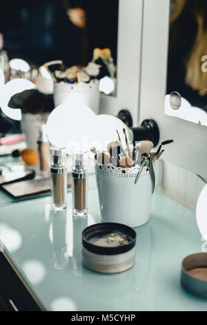 make-up brush on the wizard's table in the backlight on a glass surface with blemishes Stock Photo