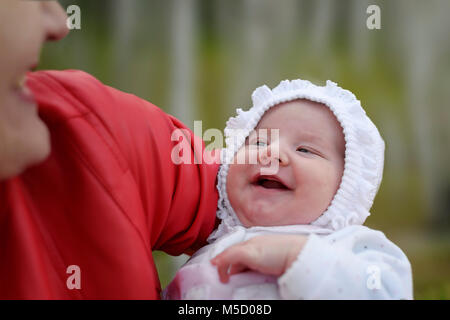 Laughing Baby. A moment of joy between a mother and suckling, a woman holding up a baby Stock Photo