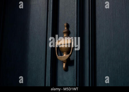 Traditional brass door knocker on a dark blue toned door, close up in London street Stock Photo