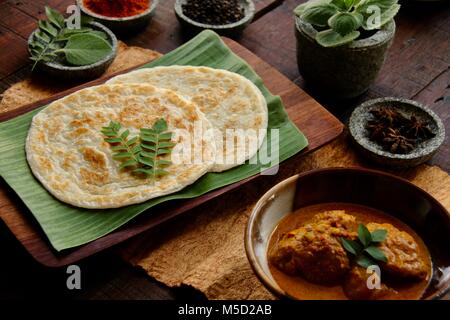 Roti Prata with Chicken Curry. Indian-influenced dish of flatbread with chicken and potato curry popular in Singapore and Malaysia. Stock Photo