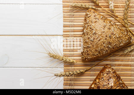 Bread and wheat on white wooden background. Stock Photo