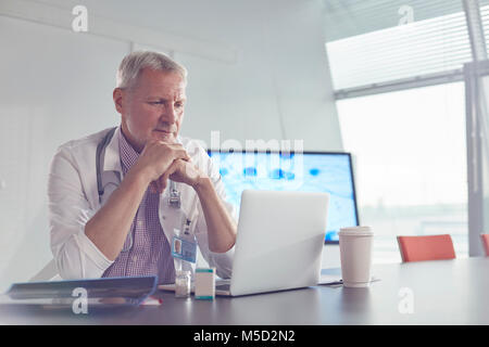 Medical scientist working at laptop in hospital conference room Stock Photo