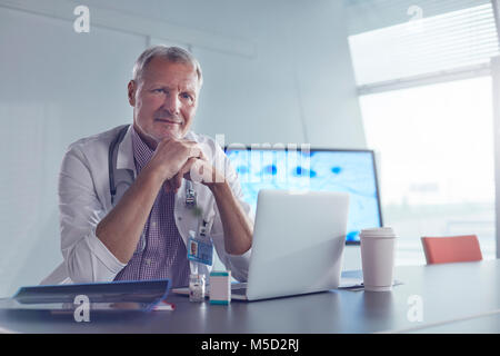 Portrait confident male medical scientist working at laptop in hospital Stock Photo