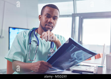 Portrait confident male surgeon with x-ray in hospital Stock Photo