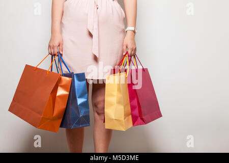 Young mother holds heavy shopping bags with products from store sale Stock Photo