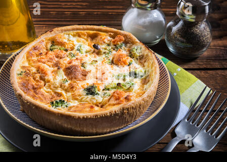 Classic salmon and broccoli quiche made from shortcrust pastry with broccoli florets and smoked salmon in a creamy free range egg custard Stock Photo