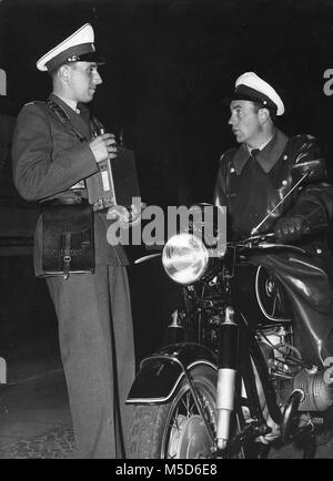 Police officer on motorcycle talking with a colleague, 1960s, Berlin, Germany Stock Photo