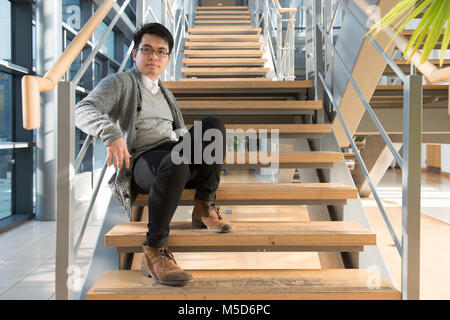 a young overseas student stands around the college campus for portraits Stock Photo