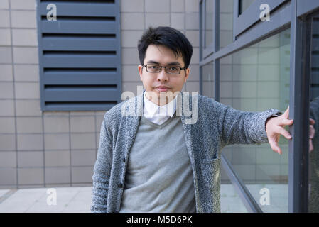 a young overseas student stands around the college campus for portraits Stock Photo