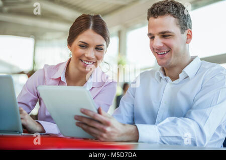 Smiling young business people using technologies in office Stock Photo