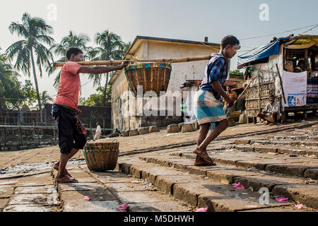 February 22, 2018 - Cox'S Bazar, Bangladesh - Two fishermen can be seen carrying fish from their boat to Cox's Bazar fish market. Unemployment rates in rural areas of Bangladesh are twice that of urban areas with people being thought of as being a burden to the whole family if they are not working. Here, I've concentrated on the positive side of a terrible situation showing the types of employment in and around the Cox's Bazar region of Bangladesh where fishing, farming and road building seem to be the most popular of careers. Credit: Marcus Valance/SOPA/ZUMA Wire/Alamy Live News Stock Photo