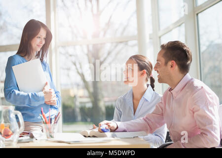 Young business people discussing at desk in creative office Stock Photo