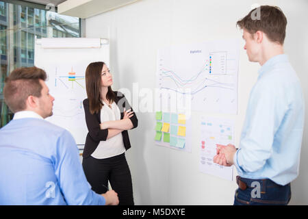 Business People Discussing Over Line Graph In Office Stock Photo