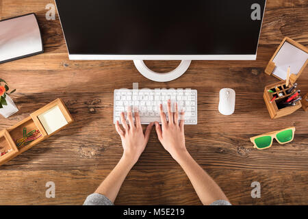 Elevated View Of A Person's Hand On Keyboard At Workplace Stock Photo