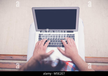 Top viewpoint male hands using notebook outdoors in urban setting while typing on keyboard, businessman freelancer working on computer while sitting o Stock Photo