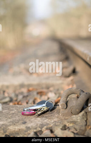 Close up of the metal fastening on a railway track with a set of lost car keys spotted on the line. Stock Photo