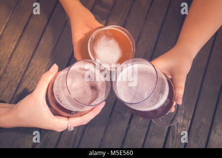 High angle view of friends cheering with home brew in pub bar restaurant Stock Photo
