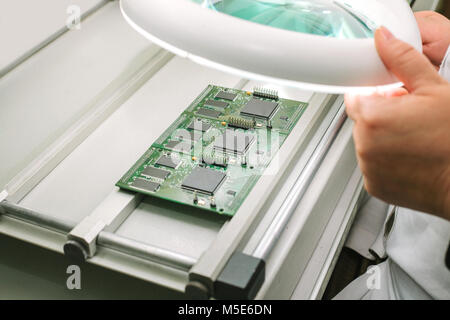 Microchip production factory. Technological process. Assembling the board. Computer expert. Stock Photo