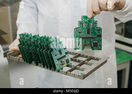Microchip production factory. Technological process. Assembling the board. Chip. Professional. Technician. Computer expert. Manufacturing. Engineering. Stock Photo
