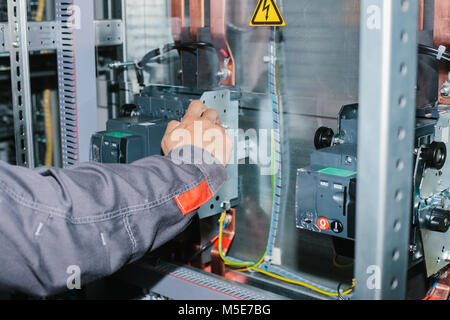 Electrician specialist checking low-voltage cabinet equipment Stock Photo
