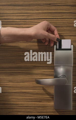 Close up of female hand locking or unlocking the door by inserting keycard in the door electronic lock Stock Photo