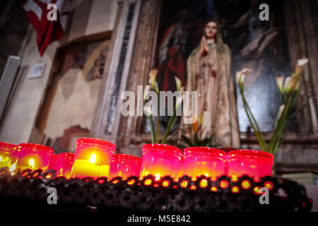 Close up of offering candels to a statue of the virgin mary Stock Photo