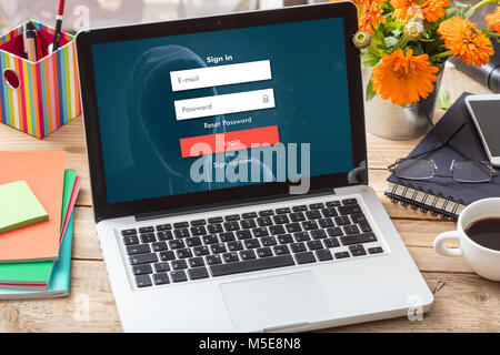 Login and password on a laptop screen on a wooden office desk Stock Photo