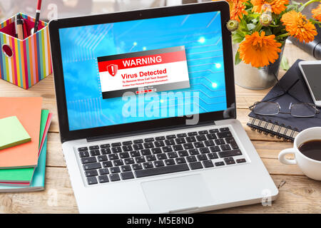 Virus detected warning message on a computer screen on a wooden office desk Stock Photo