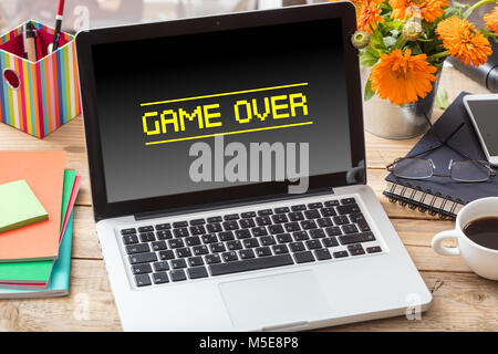 Game over on a computer screen on a wooden office desk Stock Photo