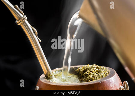 Traditional South American, Caffeine-Rich Infused Drink Mate (Yerba Mate) In A Calabash Gourd. Kettle Serves Water Into Steaming Mate Infusion. Stock Photo