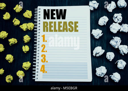 Conceptual hand writing text caption showing New Release . Business concept for Technology Software Update Written notepad note notebook book wooden b Stock Photo
