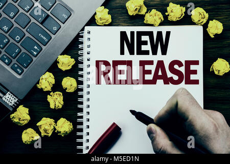Conceptual hand writing text caption New Release . Business concept for Technology Software Update Written on tablet laptop, wooden background busines Stock Photo