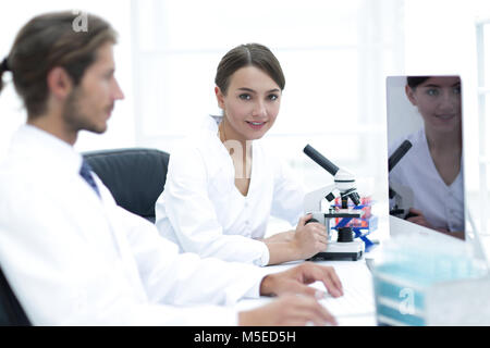 Lab expert working on a test using microscope Stock Photo