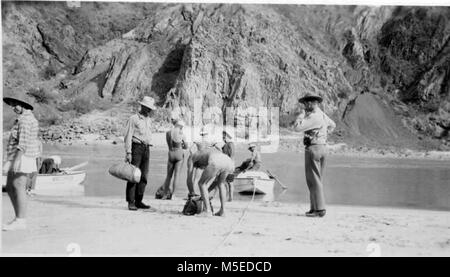 Grand Canyon Historic- Nevills Expedition c  Nevills 6th trip on the beach at phantom from left to right, nancy streator, frank wright, garth marston, norm nevills, rosalind johnston, dr. Marston, and arthur l. Brown, assistant cheif ranger. Stock Photo