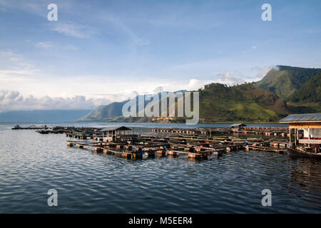 Small Indonesian Fish Farm on the shores of vast Lake Toba in North Sumatra. A beautiful and idyllic landscape image with surrounding green mountains Stock Photo