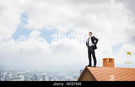 Mister boss on brick roof with arms akimbo. Mixed media Stock Photo